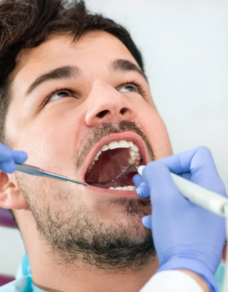 Specialist performing professional gum treatment in Al Khoud, Oman, at Al Rabeeh Dental Clinic.