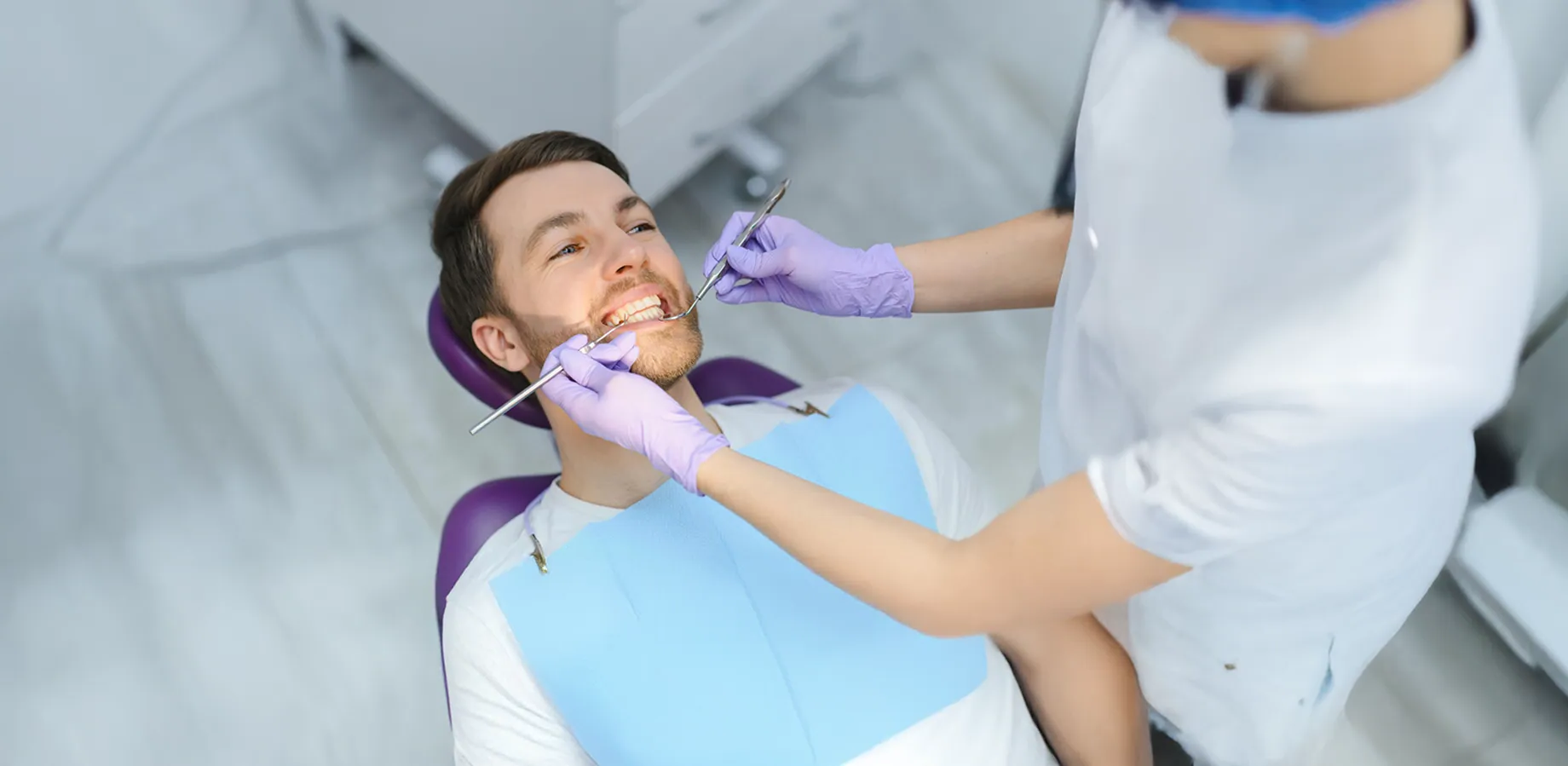 Dentist performing professional teeth whitening for a patient in Al Khoud